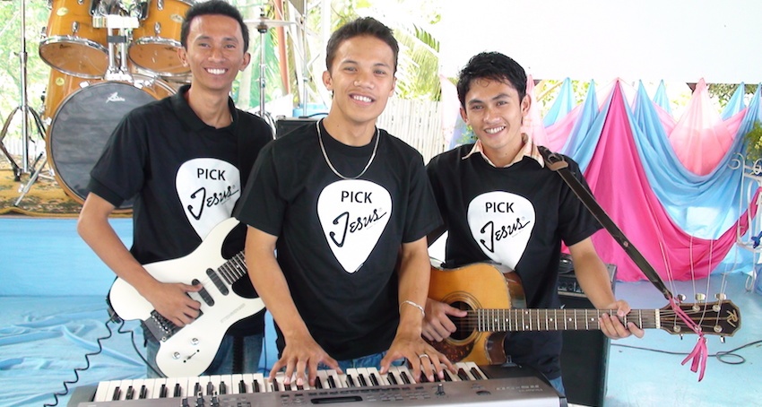 A worship team at a church in the mission field wears their Christian T-shirts proudly.